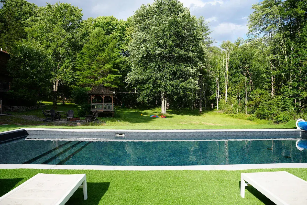 The private pool at The Acrewoods, the lawn and gazebo beyond, woods on every side