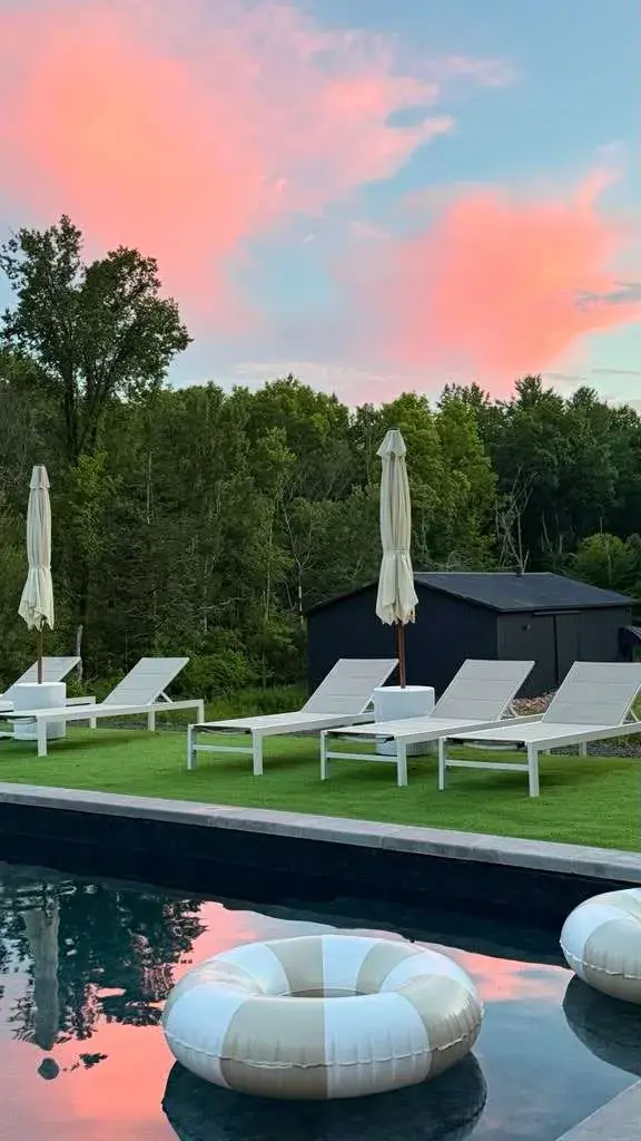 Sunset over the pool, loungers along the far edge
