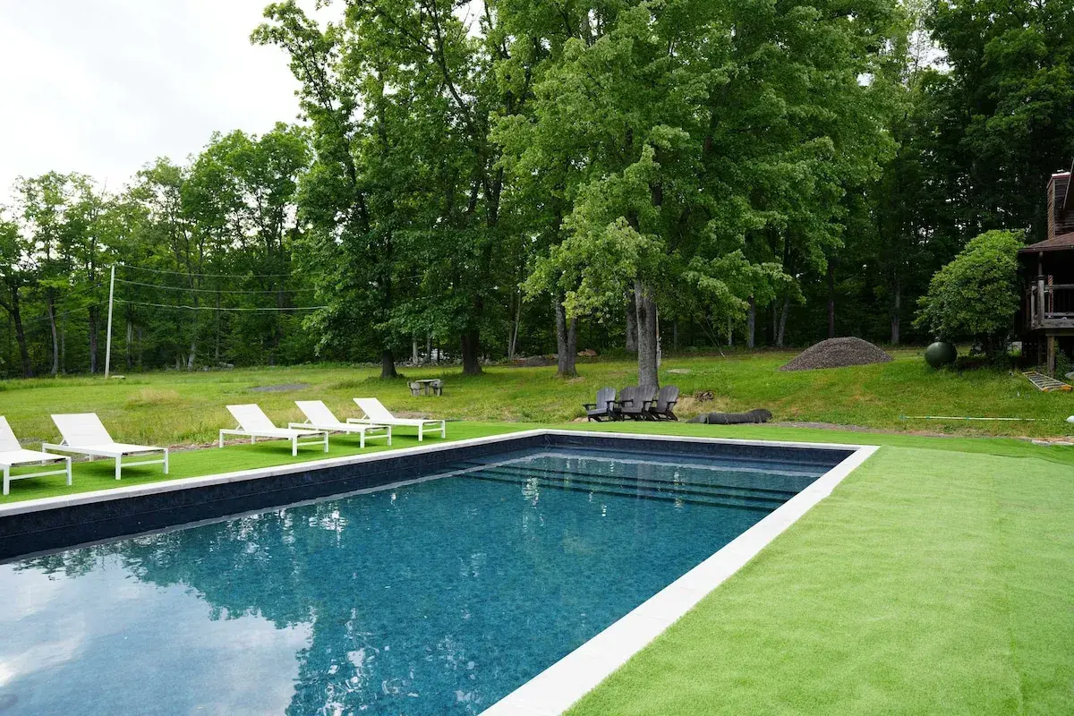 The pool in summer, loungers on the lawn