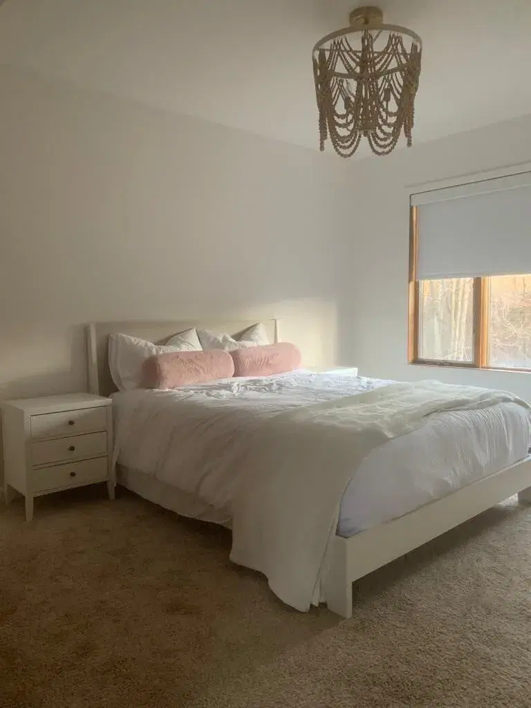 Bedroom 2 at The Acrewoods, a queen bed under a beaded chandelier
