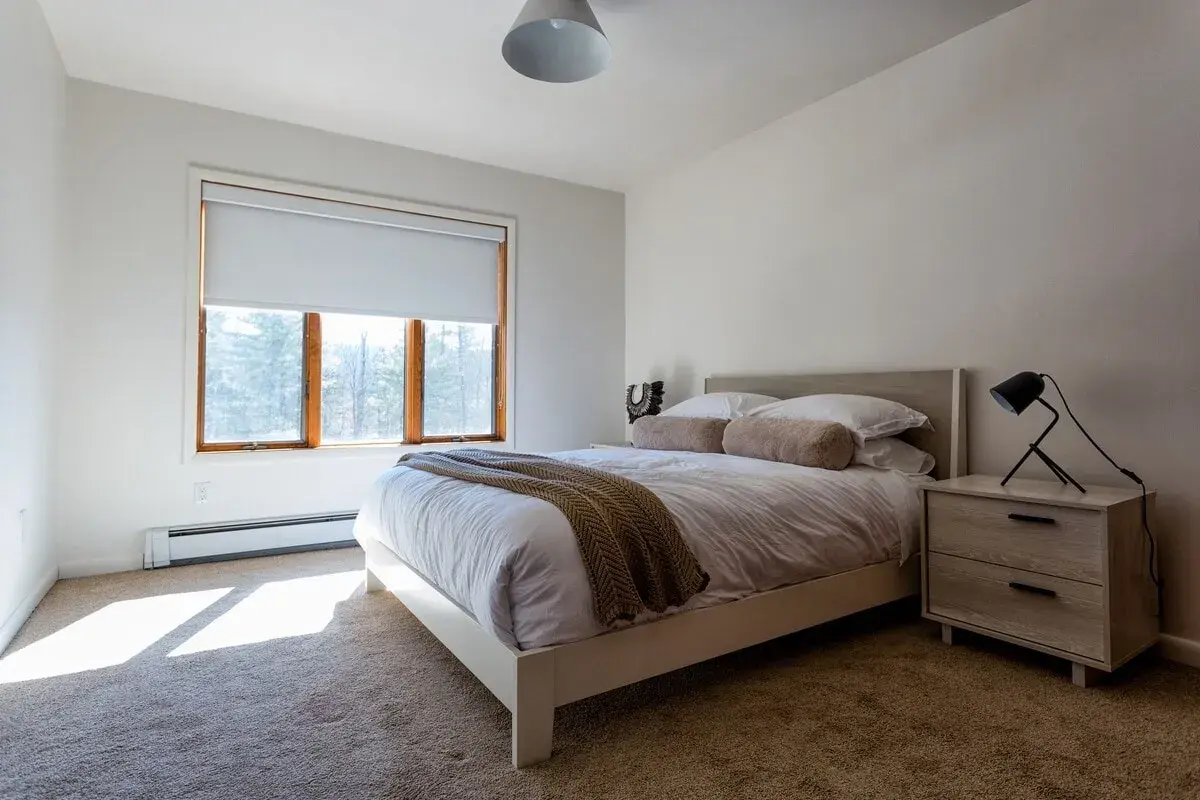 Bedroom 3 at The Acrewoods, a queen bed by the window with a bedside lamp