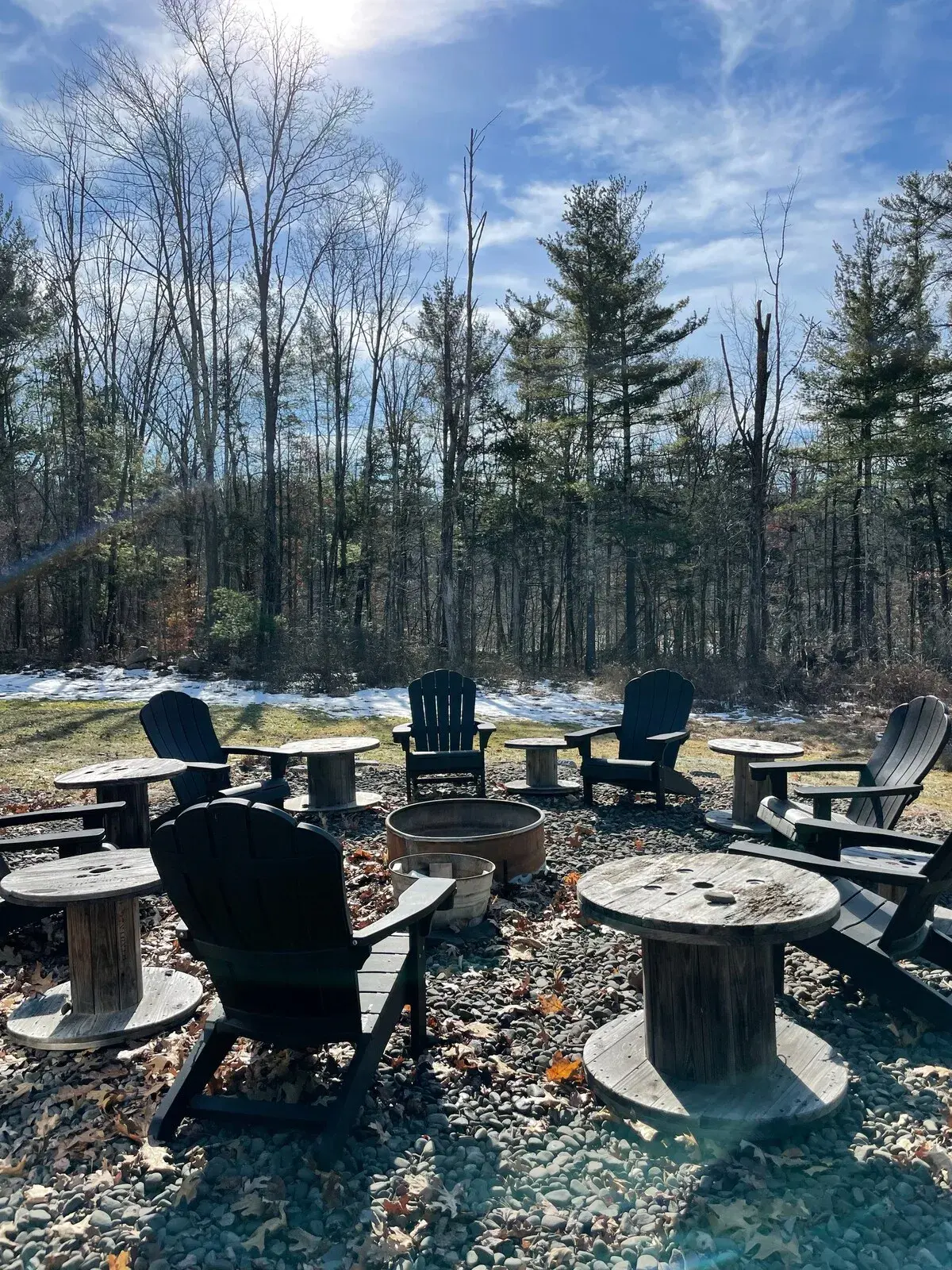 The fire pit in late winter, ringed with Adirondack chairs