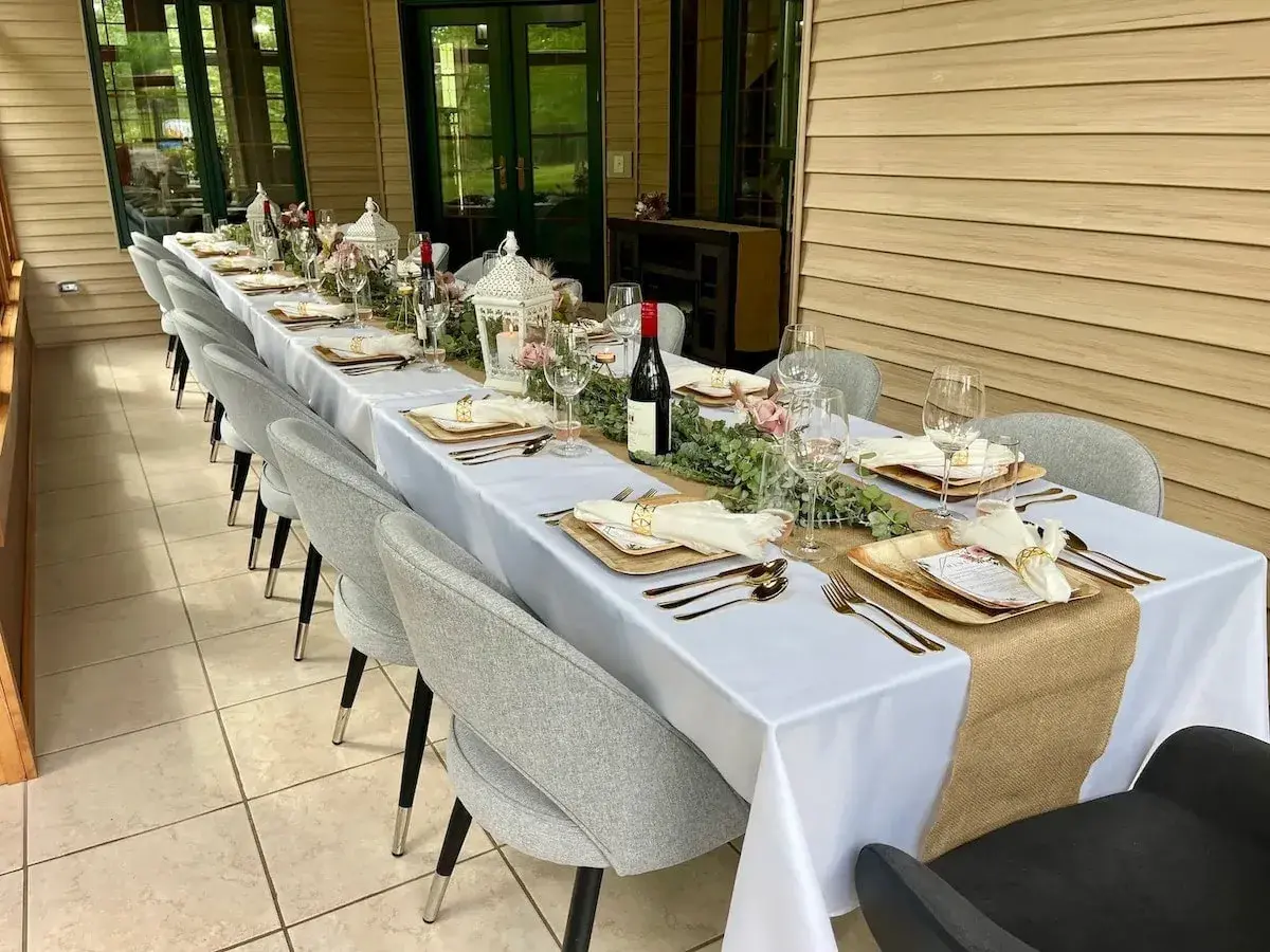 A long table set for dinner in the sunroom