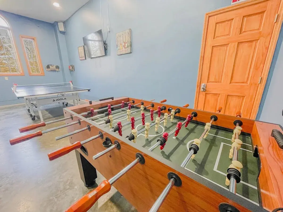 A game room with foosball and ping pong