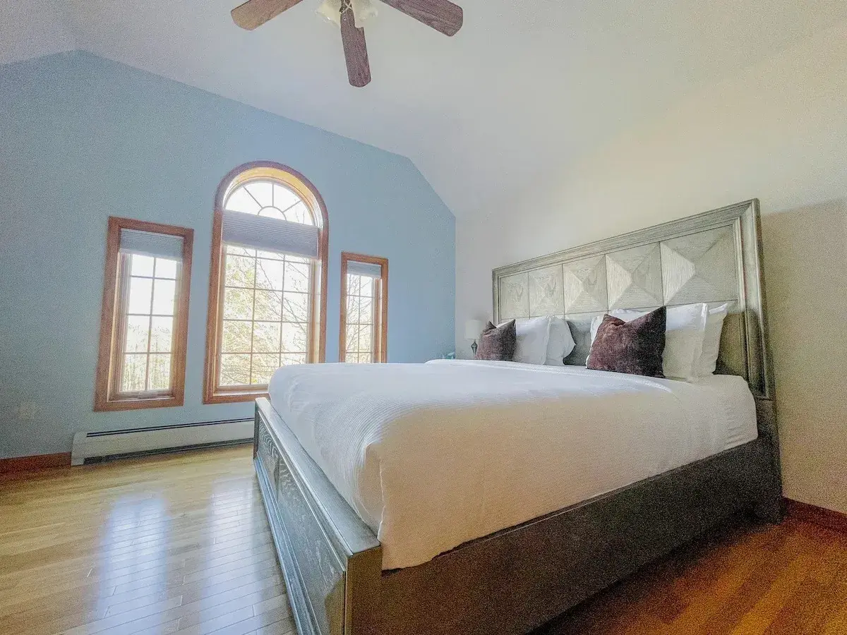 Bedroom 2 at The Birch Estate, a king bed under an arched window