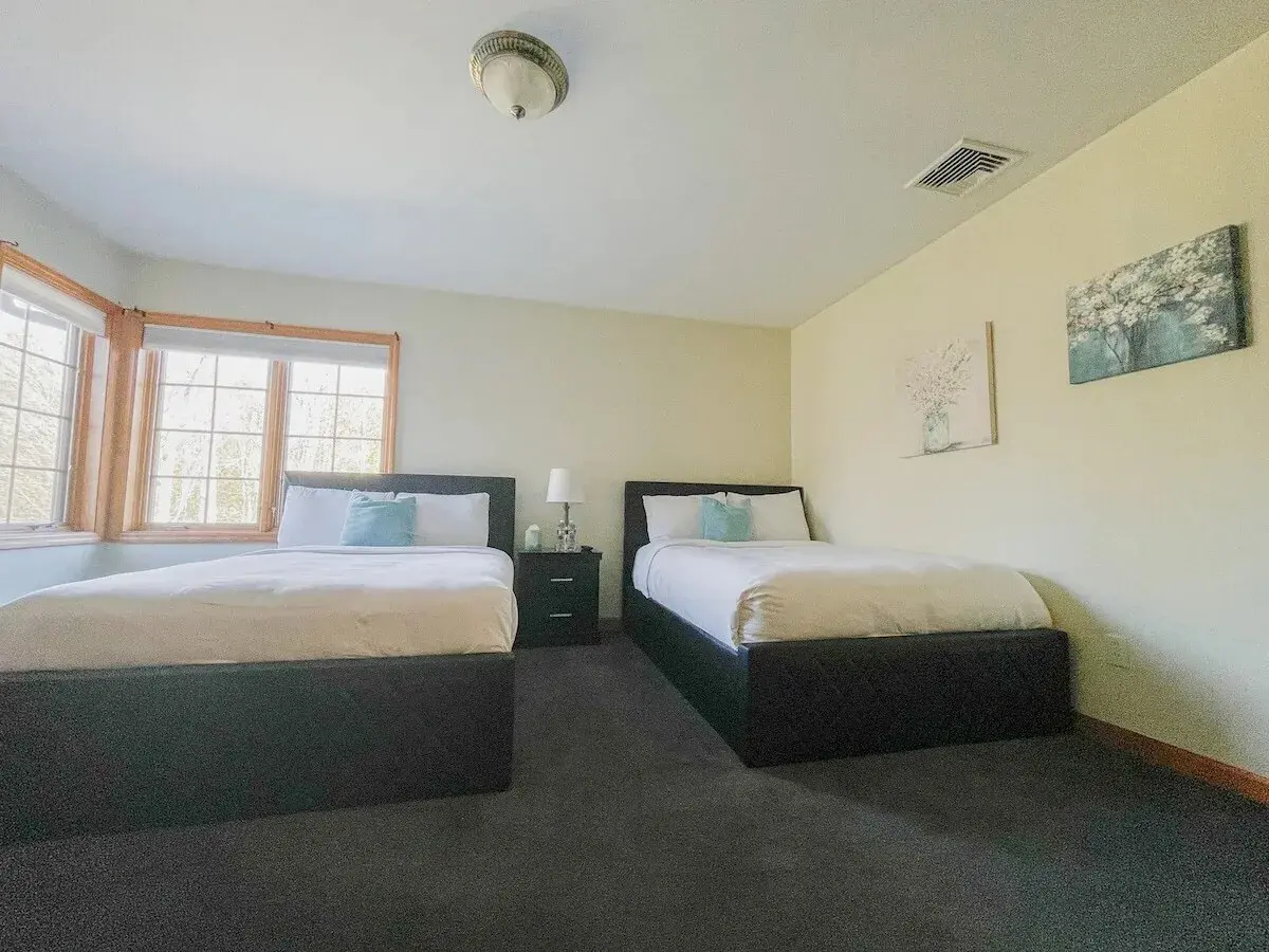 A bedroom with two beds by a bay window