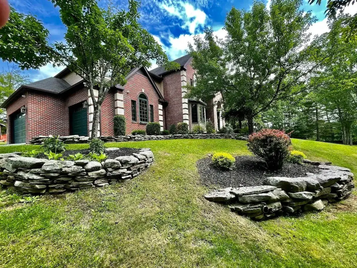 A brick facade behind stone garden beds