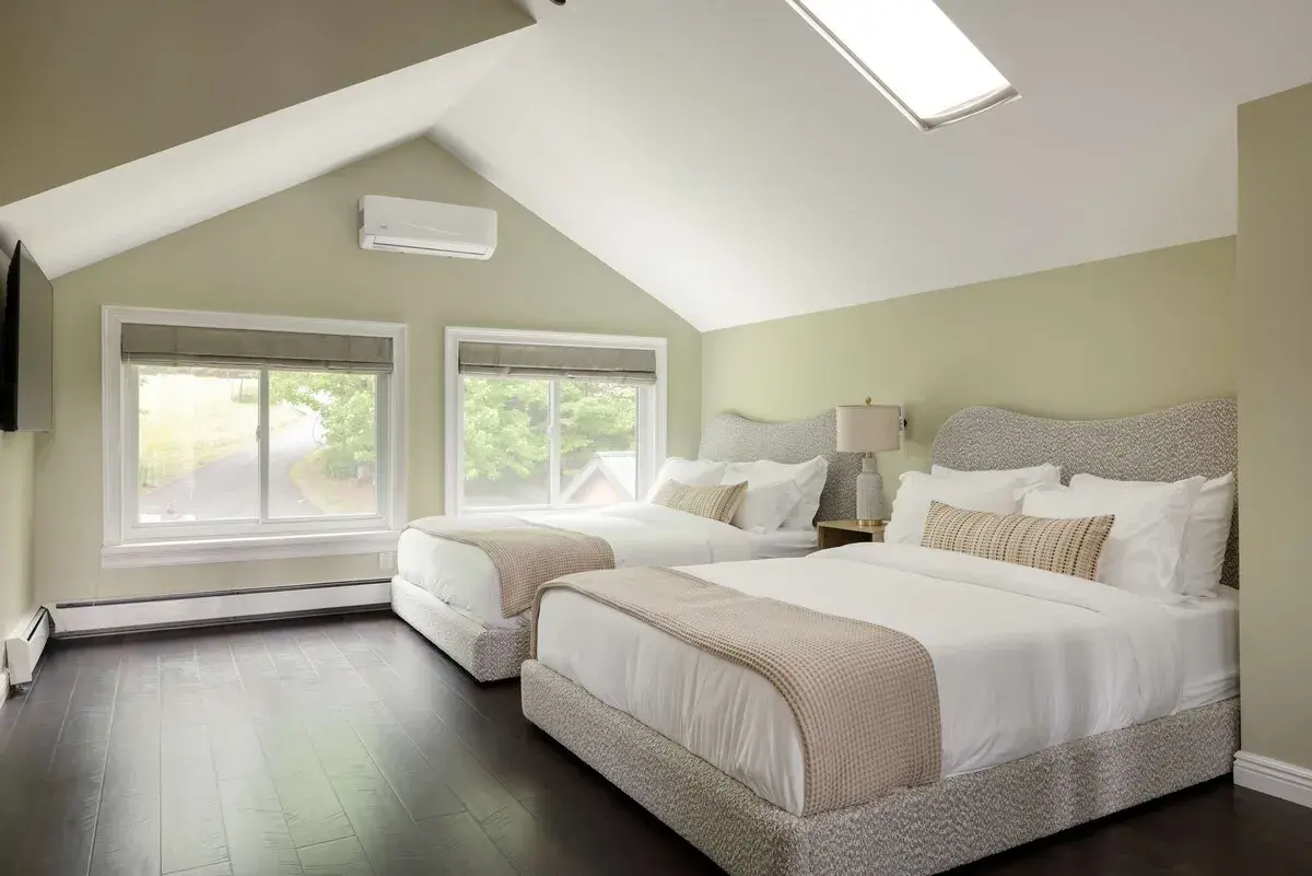 A bedroom with two beds under a skylight
