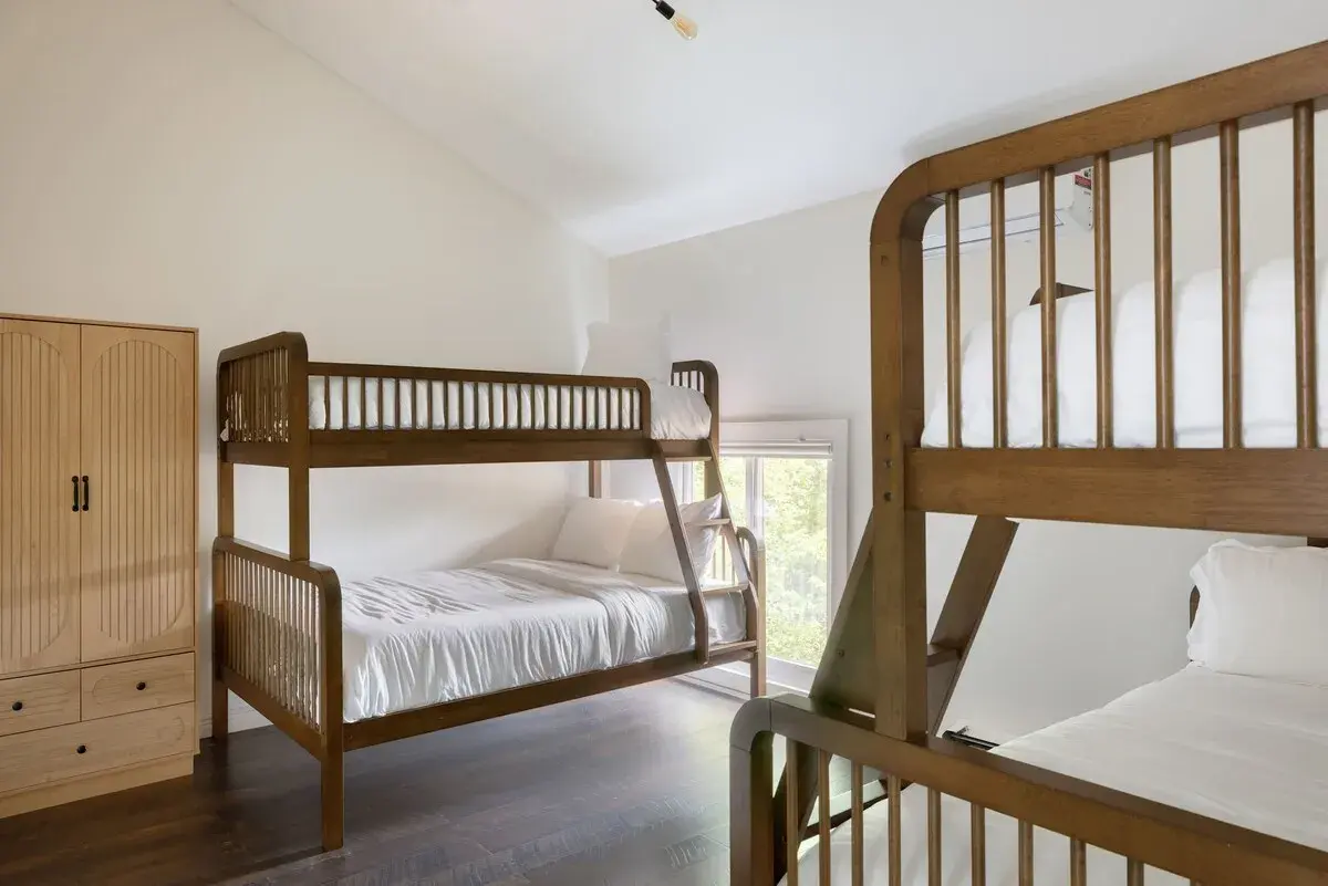 Bedroom 4 at The Lake House, a bunk room with wooden bunk beds and an armoire